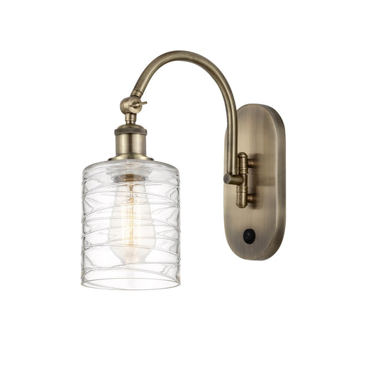 Innovations Cobbleskill 5in 1-Light Wall Sconce | Industrial Antique Brass Steel and Deco Swirl Clear Glass | Hallway & Bathroom | Model 918-1W-AB-G1113