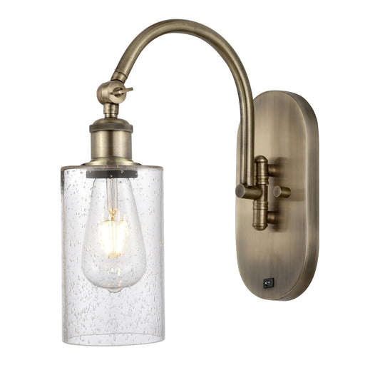 Innovations Clymer 4in 1-Light Wall Sconce | Industrial Antique Brass and Seedy Glass | Bedroom & Hallway Accent | 3.88 x 12.88 in | Model 918-1W-AB-G804
